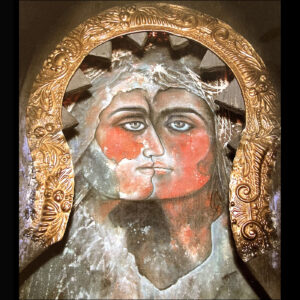 Photograph of ancient spiritual art showing two faces joined as one face.